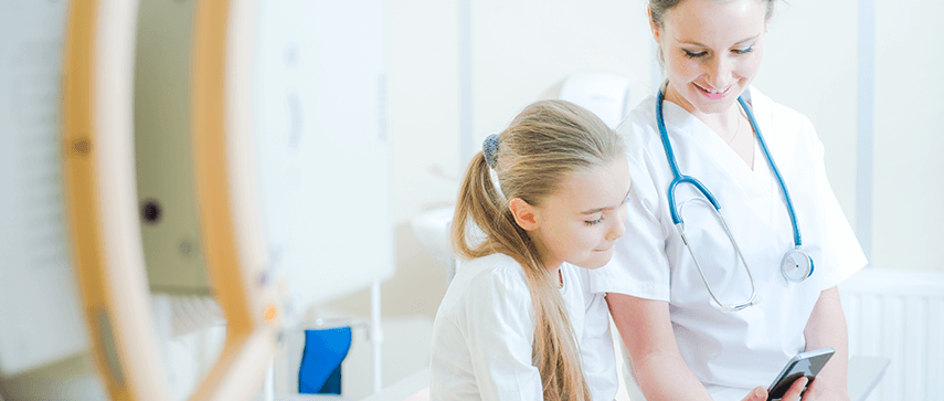 Physician engaging with a child patient with technology